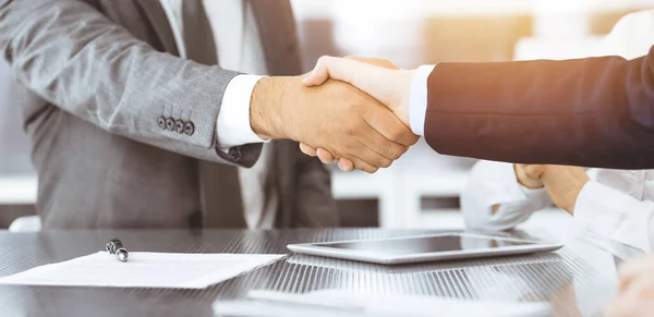 Handshake as successful negotiation ending, close-up. Unknown business people shaking hands after contract signing in modern office