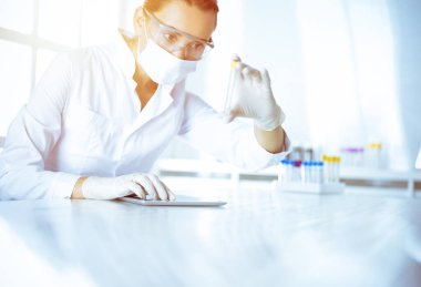 Kadın laboratuvar asistanı hastanede kan örneğini inceliyor. Tıp, sağlık ve araştırma konsepti