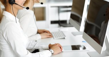 Bilinmeyen kadın müşteri hizmetleri temsilcisi kulaklık kullanarak müşterilere danışmanlık yapıyor. Yakın plan. Çağrı merkezi ve iş konsepti