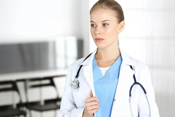 Mujer - médico de pie en la clínica. Médico en el trabajo, retrato de estudio. Concepto de medicina y salud — Foto de Stock