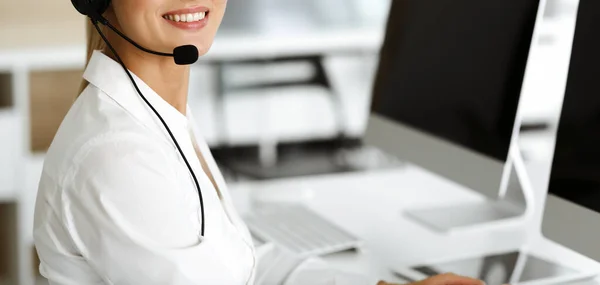 Desconocido representante de servicio al cliente femenino está consultando a los clientes en línea utilizando headset.close-up. Call center y concepto de negocio — Foto de Stock
