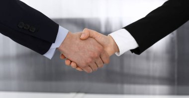 İş adamı ve kadın ofiste el sıkışıyor. İş hayatında başarı sembolü olarak el sıkışma kavramı