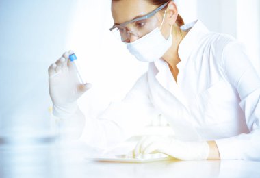 Kadın laboratuvar asistanı hastanede kan örneğini inceliyor. Tıp, sağlık ve araştırma konsepti