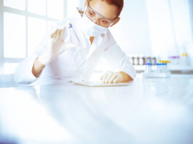 Kadın laboratuvar asistanı hastanede kan örneğini inceliyor. Tıp, sağlık ve araştırma konsepti