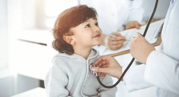 女医生在晴天用听诊器检查一名儿童病人。医生预约时可爱的Arab幼儿 — 图库照片