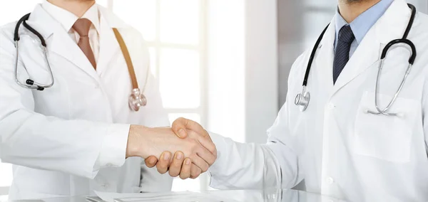 Két orvos kezet fog, hogy egyezséget kössenek a betegek kezeléséről, közelről. Orvosi segítség, orvosi koncepció — Stock Fotó