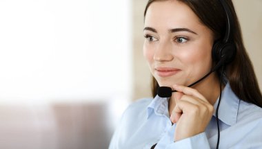 Esmer kadın müşteri hizmetleri temsilcisi kulaklık ve danışman müşteriler kullanıyor. Çağrı merkezi