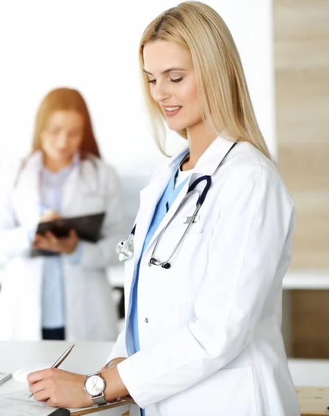 医師の女性は、晴れた病院でクリップボードを使用している間、薬の履歴記録や試験結果を制御します.医学と医療の概念 — ストック写真