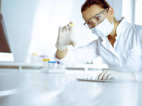 stock image Female laboratory assistant analyzing a blood sample at hospital. Medicine, health care and researching concept