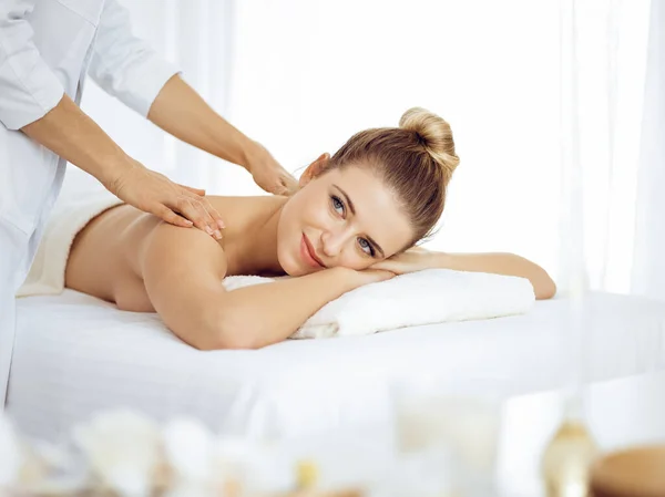 Młoda i blondynka ciesząca się masażem w salonie spa. Koncepcja piękna — Zdjęcie stockowe