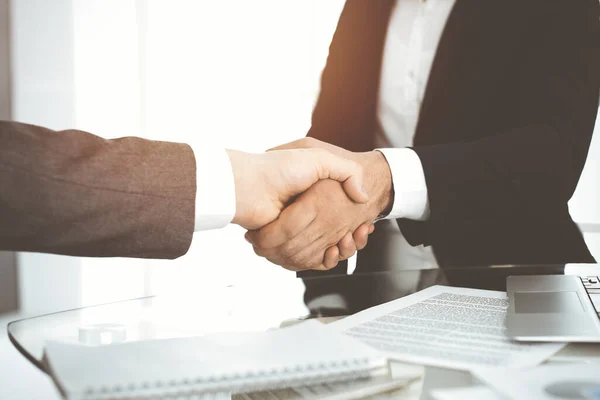 Unknown diverse business people are shaking hands finishing contract signing in sunny office, close-up. Business handshake concept — Stock Photo, Image