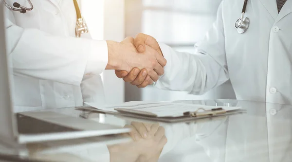 Due medici si stanno stringendo la mano come accordo sul trattamento dei pazienti, primo piano. Aiuto medico, concetto di medicina — Foto Stock