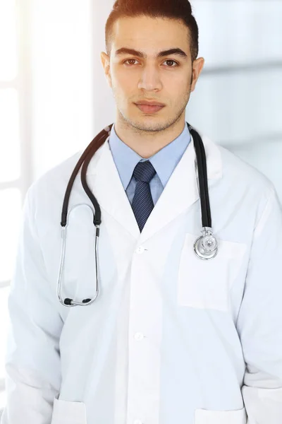 Arabische dokter man staat met gekruiste armen in de kliniek. Concept geneeskunde en gezondheidszorg — Stockfoto