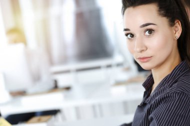 İş kadını, güneşli ofiste bilgisayar kullanıyor. Zevk ve başarı için çalışmak