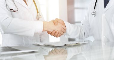 İki doktor hastaların tedavisi konusunda anlaşmak için el sıkışıyor, yakın plan. Tıbbi yardım, tıp konsepti