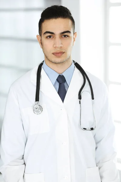 Arabische dokter man staat met gekruiste armen in de kliniek. Concept geneeskunde en gezondheidszorg — Stockfoto