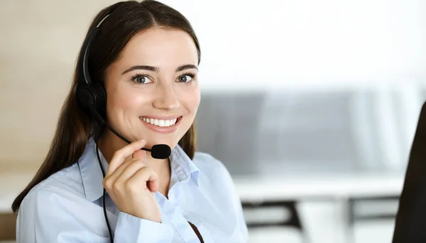 Представниця служби клієнтки Брюнета в навушниках консультується з клієнтами онлайн. Колл-центр і бізнес-люди концепція — стокове фото