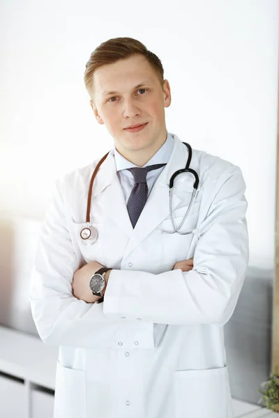 Hombre-doctor parado en una clínica soleada. Concepto de medicina — Foto de Stock