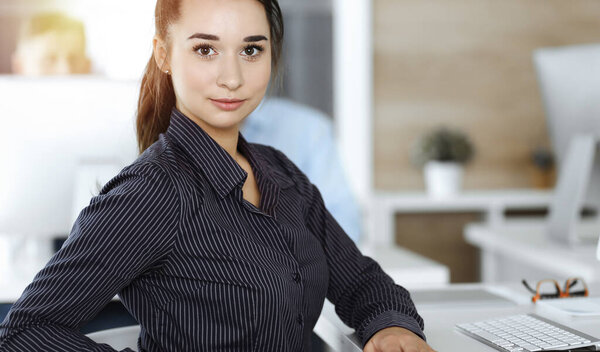 Business woman using computer at workplace in sunny office. Working for pleasure and success