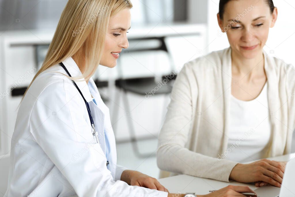 Woman-doctor sitting and communicating with her female patient in clinic. Blonde physician happy to help. Medicine concept
