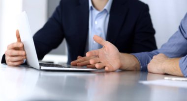 Modern ofiste birlikte çalışırken dizüstü bilgisayarı kullanan iş adamları. İş yerinde iş arkadaşı olan tanınmamış bir iş adamı ya da erkek girişimci. Takım çalışması ve ortaklık kavramı