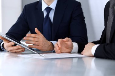 Modern ofiste birlikte çalışırken iş adamları tablet bilgisayar kullanıyorlar. İş yerinde iş arkadaşı olan tanınmamış bir iş adamı ya da erkek girişimci. Takım çalışması ve ortaklık kavramı