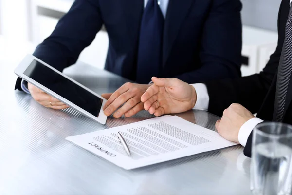 Gente de negocios que usa tableta mientras trabajan juntos en el escritorio en la oficina moderna. Empresario desconocido o empresario masculino con colega en el lugar de trabajo. Trabajo en equipo y concepto de asociación — Foto de Stock