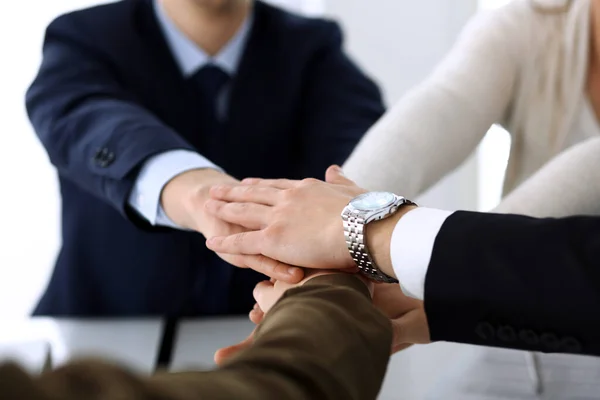 Business people group showing teamwork and joining hands or giving five after signing contract in modern office. Unknown businessman and woman with colleagues or lawyers making circle with their hands Stock Image