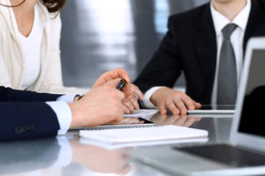 İş adamları modern ofisteki cam masasında birlikte çalışarak sözleşmeyi tartışıyor. İş arkadaşları ya da avukatları olan tanınmamış bir iş adamı ve kadın. Takım çalışması ve ortaklık