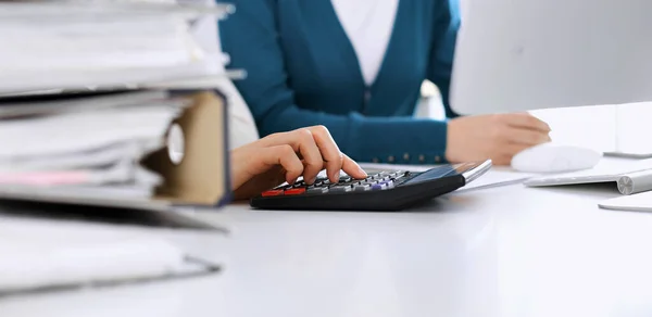 Accountant checking financial statement or counting by calculator income for tax form, hands closeup. Business woman sitting and working with colleague at the desk in office. Tax and Audit concept — Stock Photo, Image