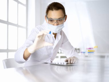 Kadın laboratuvar asistanı hastanede kan örneğini inceliyor. Tıp, sağlık ve araştırma konsepti