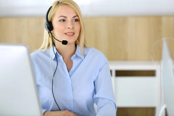 Centro de llamadas. Mujer rubia de negocios sentada en auriculares en la oficina de servicio al cliente. Concepto de negocio de telesales u ocupación de oficina en el hogar — Foto de Stock