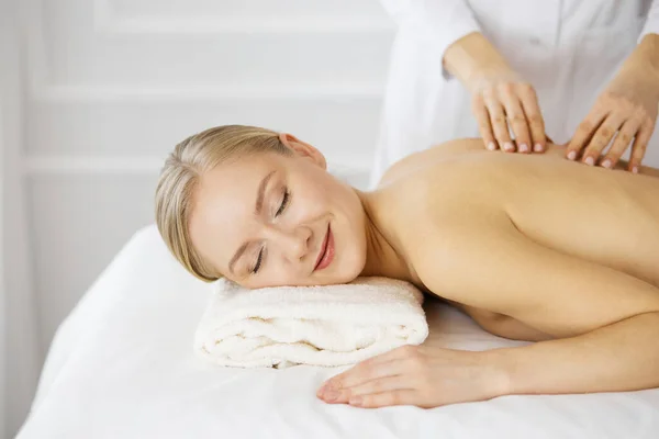 Belle femme caucasienne bénéficiant d'un massage du dos avec les yeux fermés. Concept de salon de beauté et spa — Photo