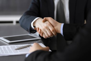 İş adamı, modern ofiste iş arkadaşı veya ortağıyla el sıkışıyor. Yakın plan. Toplantıda bilinmeyen iş adamları var. Takım çalışması, ortaklık ve el sıkışma kavramı