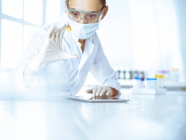 Kadın laboratuvar asistanı hastanede kan örneğini inceliyor. Tıp, sağlık ve araştırma konsepti