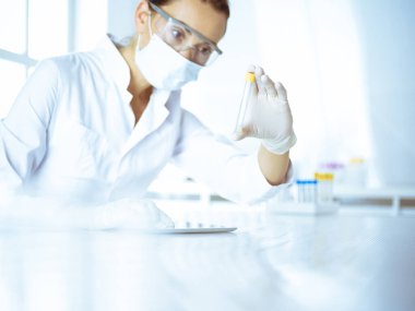 Kadın laboratuvar asistanı hastanede kan örneğini inceliyor. Tıp, sağlık ve araştırma konsepti