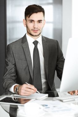 Modern ofiste bilgisayarla çalışan bir iş adamı. İş yerindeki erkek girişimci ya da yönetici. İş konsepti