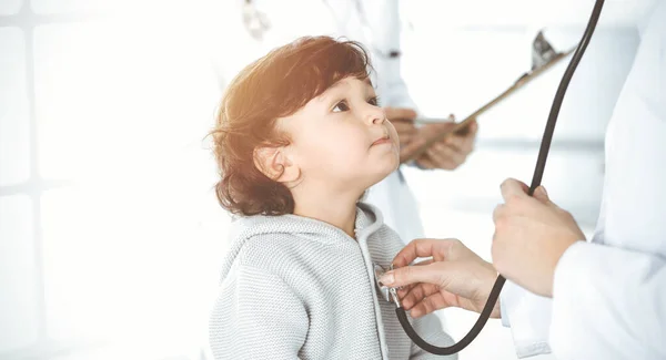 Femme-médecin examinant un enfant patient par stéthoscope dans une clinique ensoleillée. Bébé arabe mignon sur rendez-vous chez le médecin — Photo