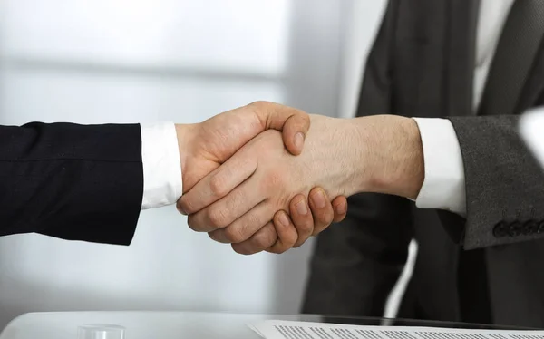 Pessoas de negócios diversas desconhecidas estão apertando as mãos terminando a assinatura do contrato, close-up. Conceito de negócio e aperto de mão — Fotografia de Stock