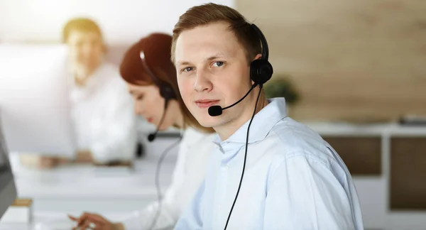 Empresario trabajando en la oficina de servicio al cliente. Grupo de operadores diversos en el trabajo en el centro de llamadas soleado —  Fotos de Stock