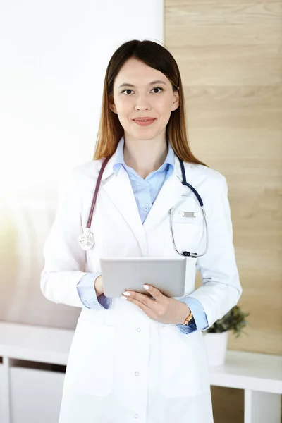 Asiatische Ärztin im sonnigen Krankenhausbüro. Medizinkonzept — Stockfoto