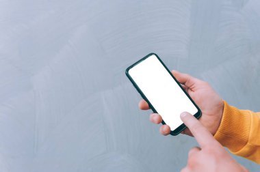 Model teknolojisi. Adam akıllı telefonu yakın planda tutuyor.