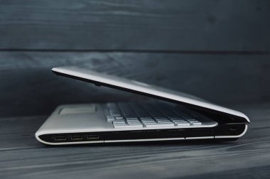 Gri ahşap arka planda beyaz laptop