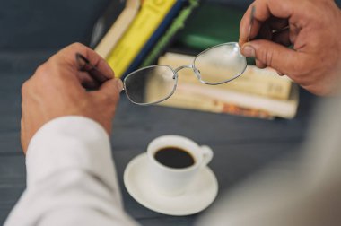 Eğitim konusunda bir kavram. Gözlüklü bir adam kitap okur, arka planda, kahveli.