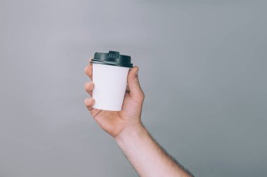 Logo ve tasarım için bir model. Bir adam elinde bir bardak kahve tutuyor.