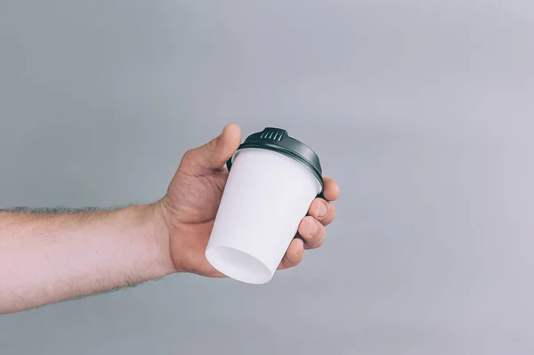 Logo ve tasarım için bir model. Bir adam elinde bir bardak kahve tutuyor.