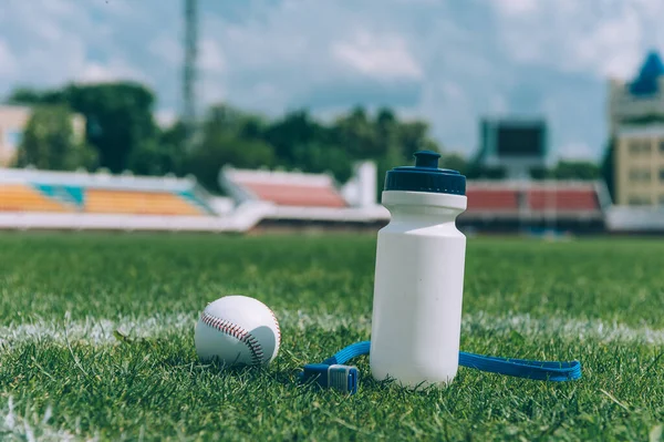 Sports water bottle with a whistle and a baseball ball in a green stadium