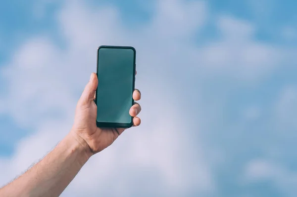 Gökyüzüne karşı bir insanın elindeki akıllı telefonu taklit et.