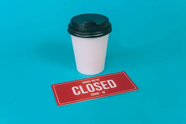 Red plate Sorry We\'re Closed COVID-19 with a plastic cup of coffee