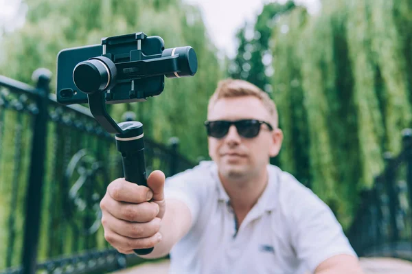 Doğadaki blogcu, el kamerasıyla akıllı telefondan video çekiyor.